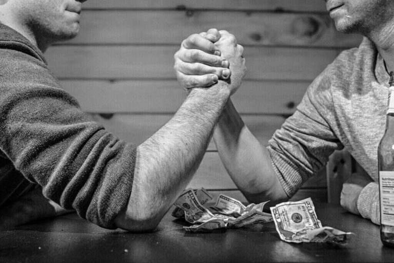 Arm wrestling with money on table as bet.